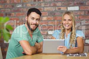 Portrait of smiling man and woman with digital tablet