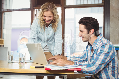 Man working on laptop with colleague