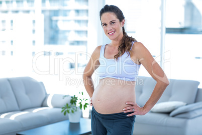 Portrait of cheerful pregnant woman with hands on hip