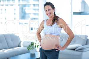 Portrait of cheerful pregnant woman with hands on hip