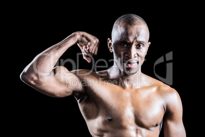 Portrait of muscular man smiling while flexing muscles