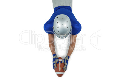 Rear view of American football player reaching towards ball
