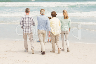 Multi generation family walking by the shore