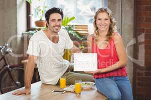 Smiling business people showing digital tablet in office