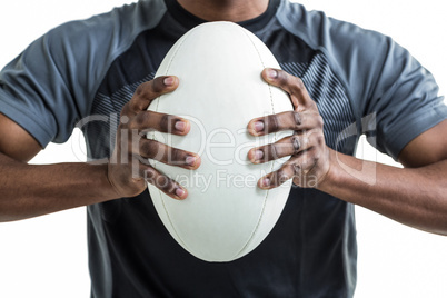 Cropped image of sportsman pressing rugby ball