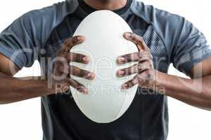 Cropped image of sportsman pressing rugby ball