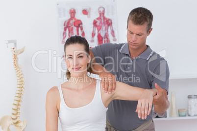 Doctor stretching a young woman arm