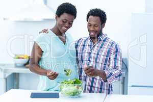 Couple having salad while standing