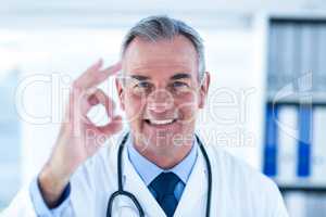 Portrait of male doctor showing ok sign in clinic