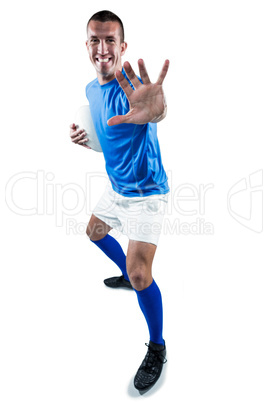 Full length portrait of happy rugby player defending