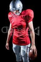 American football player looking down while standing