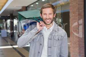 Young happy smiling man holding shopping bags