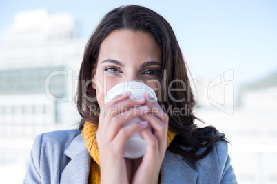 Smiling beautiful brunette drinking coffee