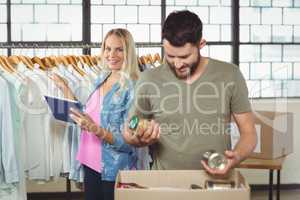 Man separating products while woman holding digital tablet