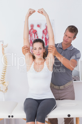 Doctor stretching a young woman arm