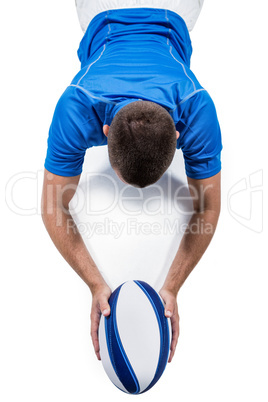 Rugby player lying in front with ball