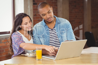 Business people pointing towards laptop