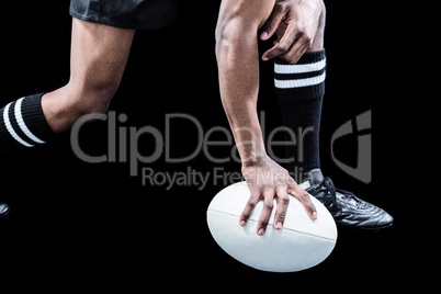 Low section of sportsman holding rugby ball