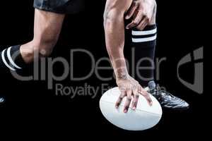 Low section of sportsman holding rugby ball