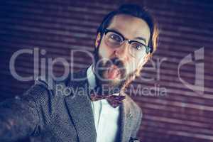 Portrait of stylish man sticking out his tongue