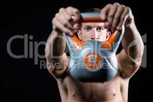 Confident shirtless athlete showing kettlebell