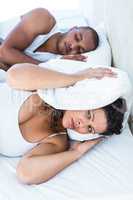 Disturbed wife sleeping besides snoring husband