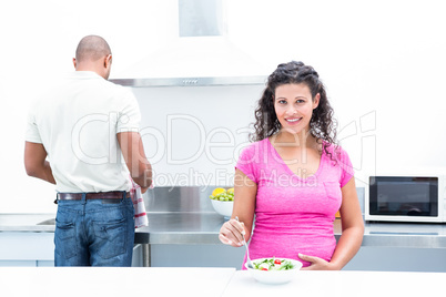 Portrait of happy wife with husband helping in kitchen