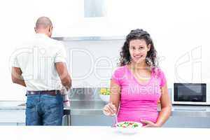 Portrait of happy wife with husband helping in kitchen