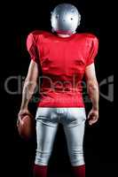 Rear view of American football player with ball