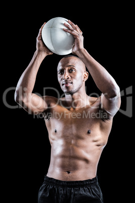 Shirtless athlete throwing rugby ball