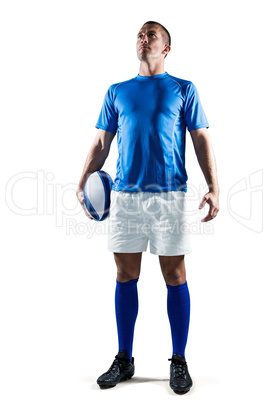 Full length of confident rugby player holding ball