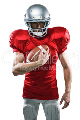 Portrait of confident American football player in red jersey hol