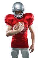 Portrait of confident American football player in red jersey hol
