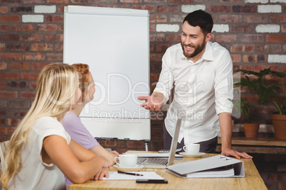 Businessman smiling while explaining to colleagues