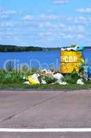 Overflowing barrel with rubbish and waste disposal on the waterf