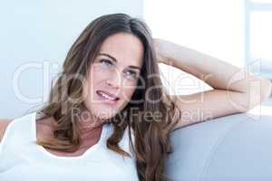 Smiling pregnant woman relaxing on sofa