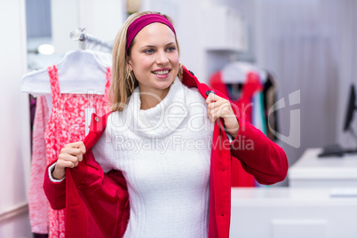 Smiling woman putting on red coat