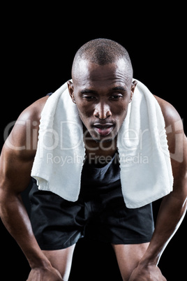 Muscular man resting while keeping hand on knee