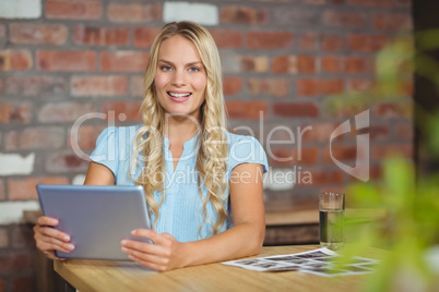 Portrait of cheerful businesswoman holding tablet