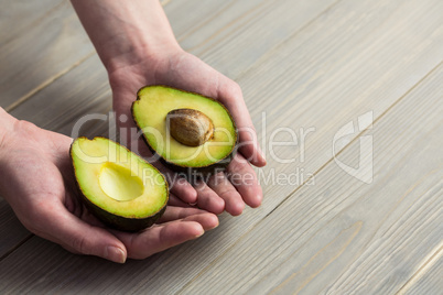 Woman showing fresh avocado