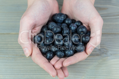 Woman showing handful of blueberries