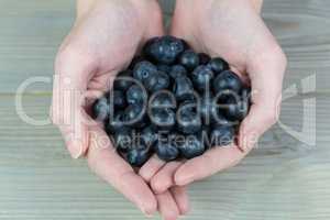 Woman showing handful of blueberries