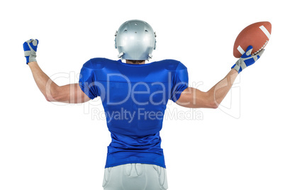 Rear view of American football player holding ball