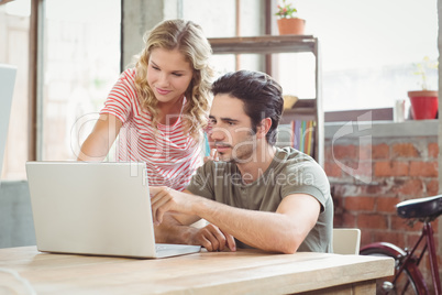 Man and woman working on laptop in office