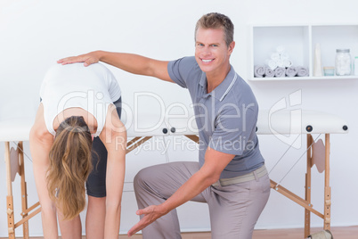 Happy doctor stretching a woman back
