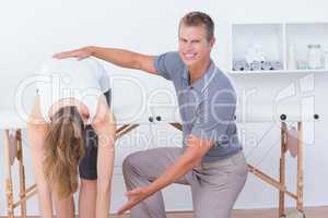 Happy doctor stretching a woman back