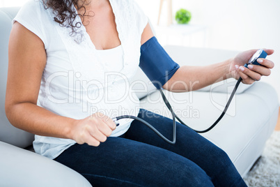 Pregnant woman checking blood pressure