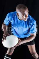 Confident sportsman looking away while playing rugby