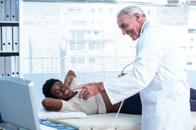 Male doctor showing ultrasound monitor
