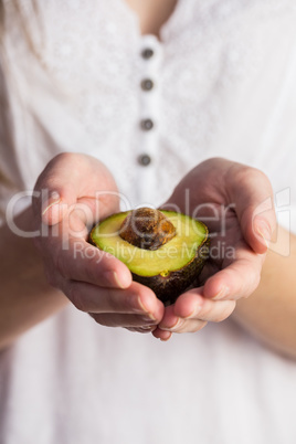 Woman showing fresh avocado